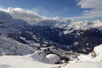 View from the Männlichen of snow-covered Wengen and the Lauterbrunnen Valley in winter.