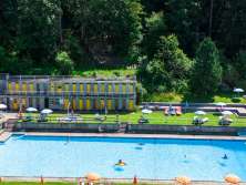 Piscine et café au cœur du village de Wengen, avec une vue panoramique sur la vallée de Lauterbrunnen.