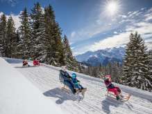 Winter in the Haslital: A young family sledding on the Hasliberg.
