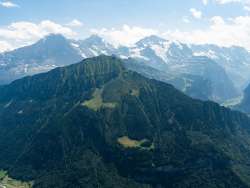 A view of the "Grüner Männlicher" and, in the background, the summer trio of the Eiger, Mönch, and Jungfrau