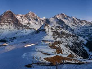 A panoramic view of the snow-covered Royal Walk, featuring the Krone, the Männlich, and the Eiger, Mönch, and Jungfrau at dusk.