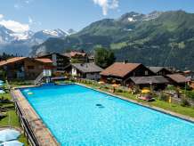 A swimming pool and café in the heart of the village of Wengen, surrounded by panoramic views of the Lauterbrunnen Valley.