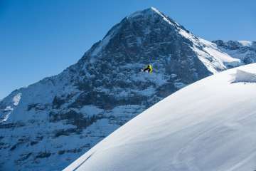 Snowboarding at the Grindelwald-First ski resort. Jumps in fresh powder snow with the Eiger in the background.