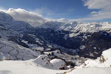 View from the Männlichen of snow-covered Wengen and the Lauterbrunnen Valley in winter.