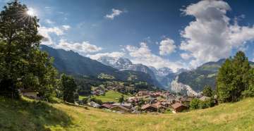 Behind the summery village of Wengen, you can see the Lauterbrunnen Valley with its steep cliffs.
