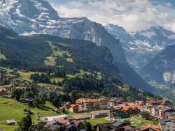 Behind the summery village of Wengen, you can see the Lauterbrunnen Valley with its steep cliffs.
