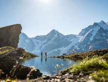 Hike with a dog at Grauseeli. The snow-covered mountain panorama, featuring the Eiger, Mönch, and Jungfrau, stretches out in the background.